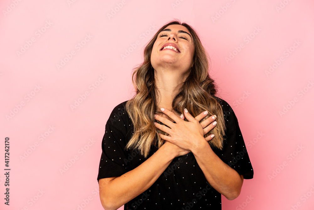 Young caucasian woman isolated laughing keeping hands on heart, concept of happiness. Young caucasian woman isolated laughing keeping hands on heart, concept of happiness.
