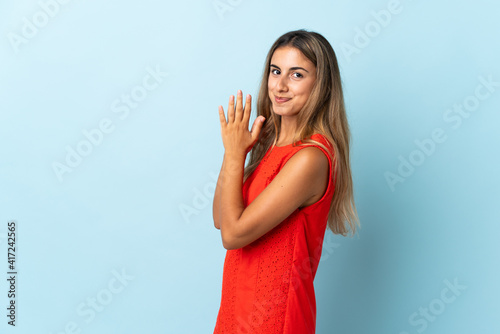 Young hispanic woman over isolated blue background scheming something