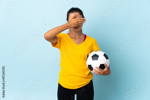 Young hispanic football player woman over isolated on blue background covering eyes by hands. Do not want to see something © luismolinero