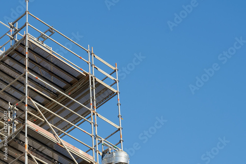 Construction scaffolding against a clear blue sky.