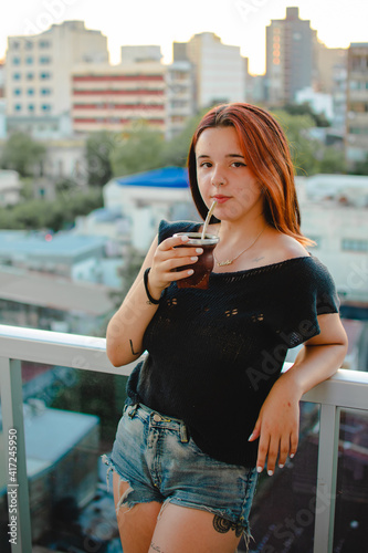 jovencita tomando mate en el balcon de su casa  © Christian