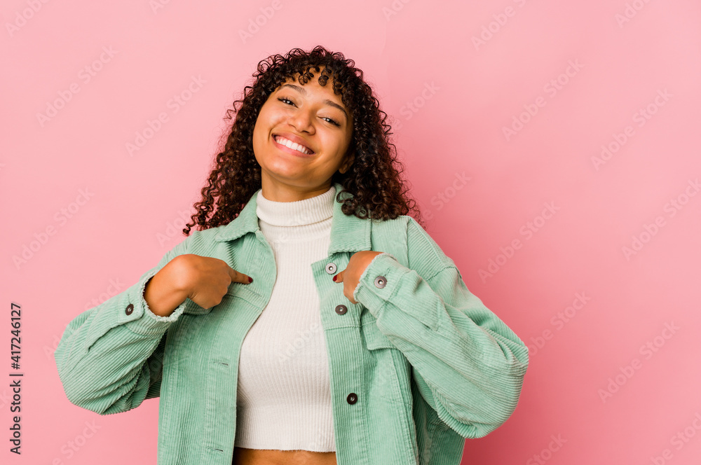 Young african american afro woman isolated surprised pointing with finger, smiling broadly.