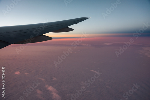 Obraz na płótnie Aerial View from an Airplane. Flying above Clouds at Pink Sunrise w salonie