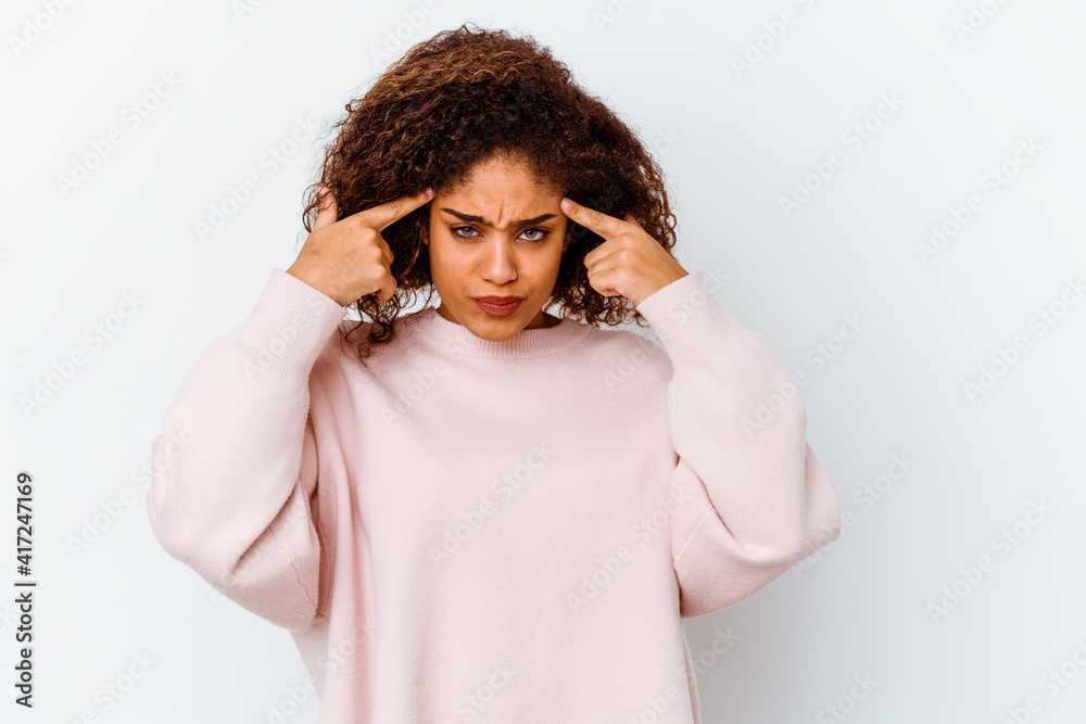 Young african american woman isolated on white background focused on a task, keeping forefingers pointing head.