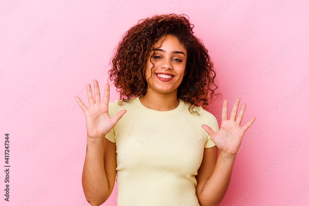Young african american woman isolated on pink background showing number ten with hands. Young african american woman isolated on pink background showing number ten with hands.