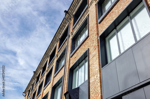 Brick building with windows and downspout against blue sky