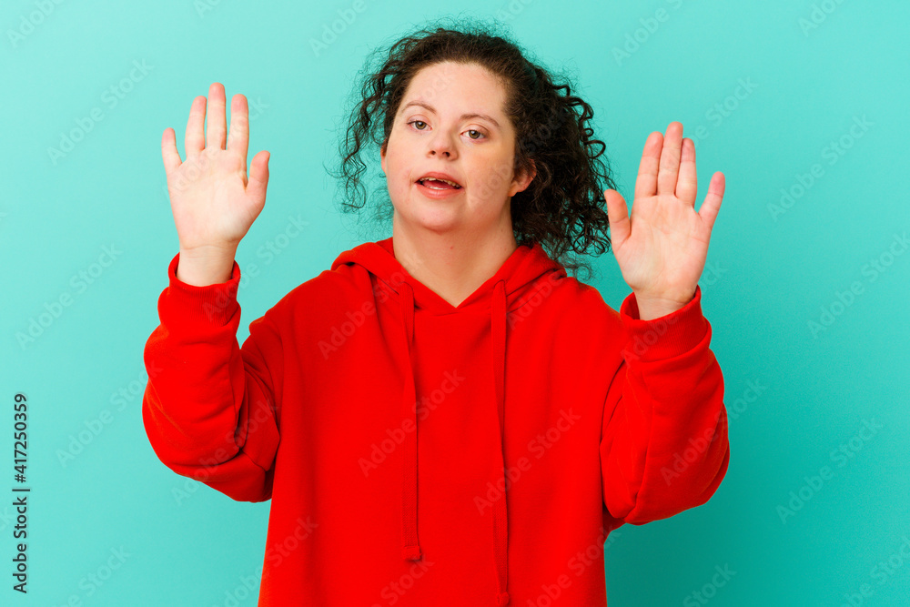 Woman with Down syndrome isolated celebrating a victory or success, he is surprised and shocked. Woman with Down syndrome isolated celebrating a victory or success, he is surprised and shocked.