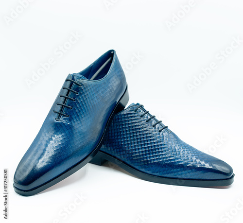 Cow leather dress shoes imitating snakeskin in turquoise blue color on white background.
