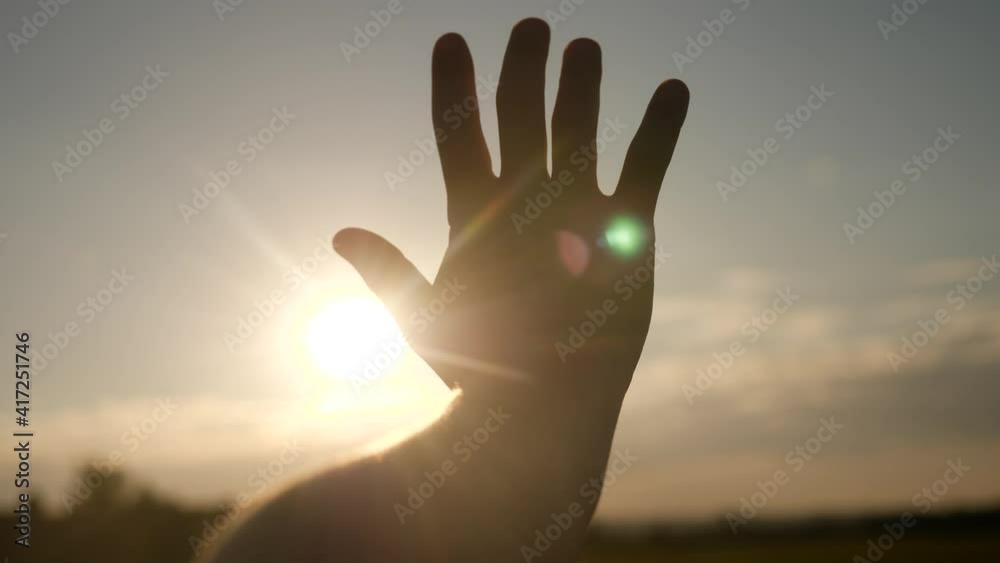 girl stretches out her hand in the sun. faith in god dream a religion sunlight concept. hand sun in the close-up silhouette dream of happiness girl stretches out her hand in the sun. faith in god dream a religion sunlight concept. hand sun in the close-up silhouette dream of happiness