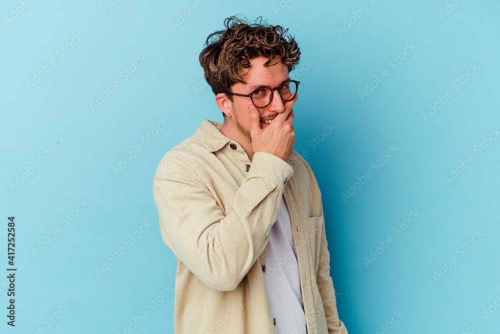 Young caucasian man wearing eyeglasses isolated on blue background scared and afraid. Young caucasian man wearing eyeglasses isolated on blue background scared and afraid.