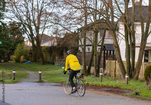 a man in a yellow jacket and helmet riding in the countryside on a bicycle