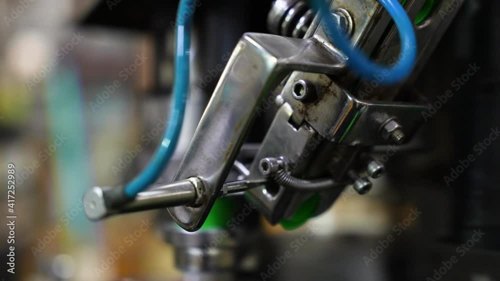 Close up of automatic plastic bottle cap capping machine. Close up of automatic plastic bottle cap capping machine.