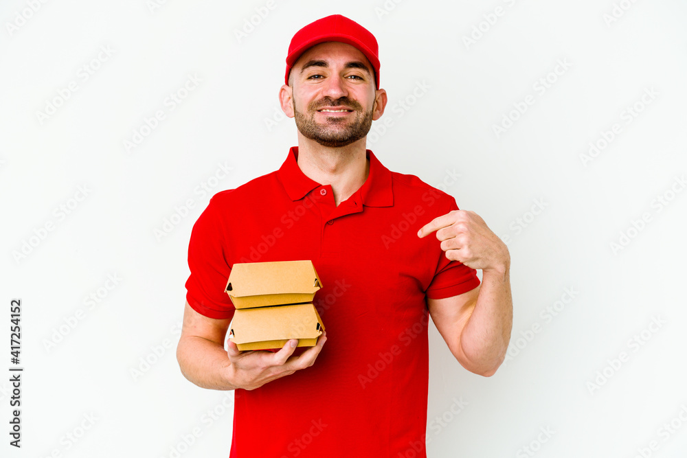 Young caucasian delivery man isolated on white background person pointing by hand to a shirt copy space, proud and confident Young caucasian delivery man isolated on white background person pointing by hand to a shirt copy space, proud and confident