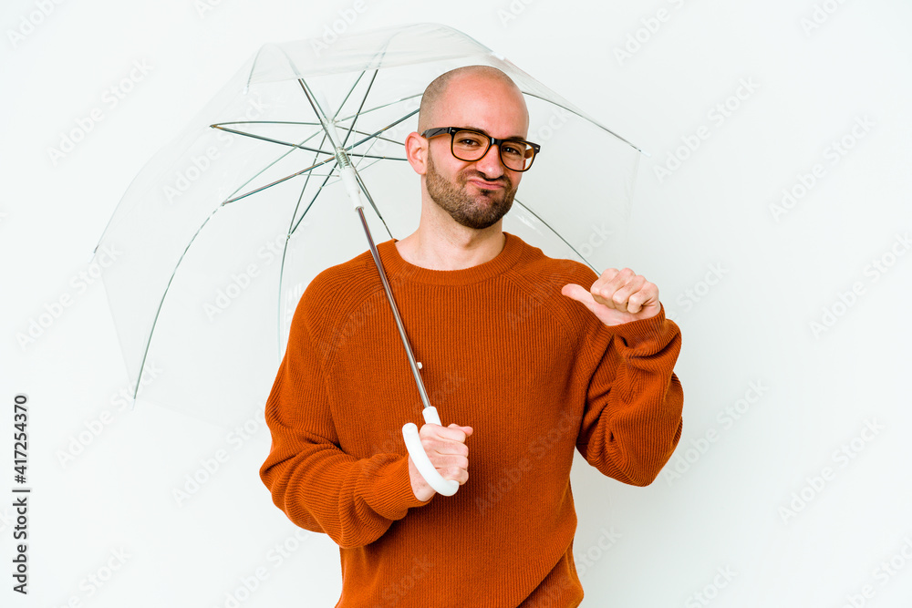 Young bald man holding an umbrella isolated feels proud and self confident, example to follow. Young bald man holding an umbrella isolated feels proud and self confident, example to follow.