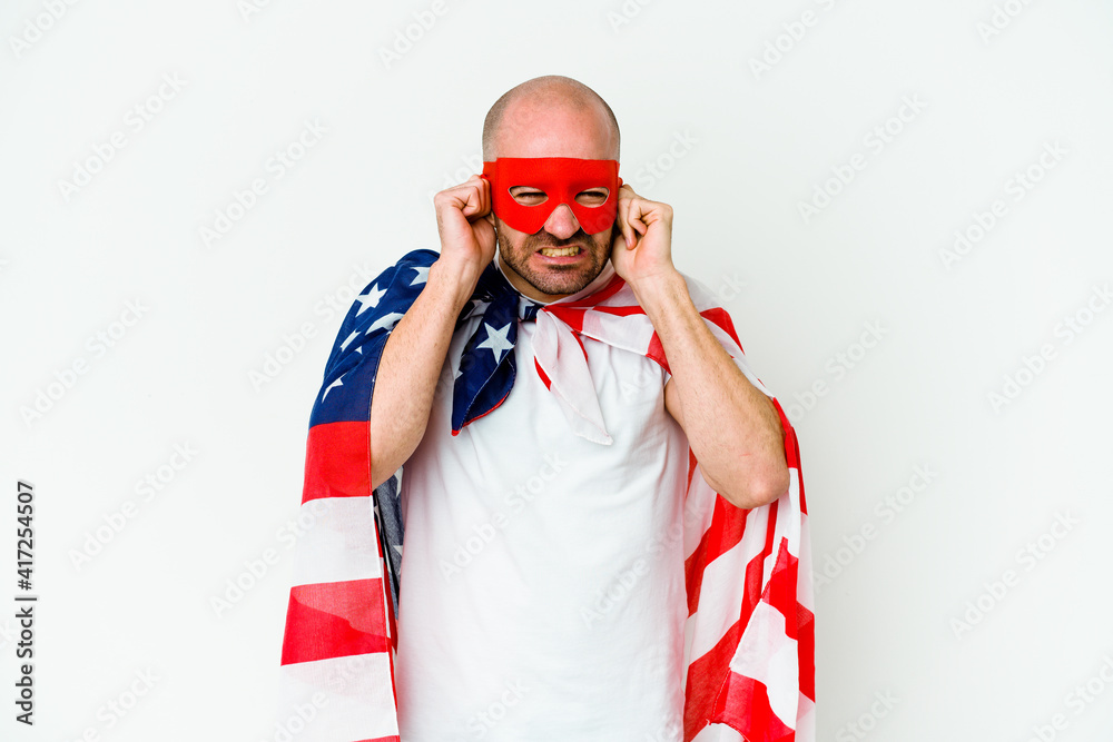 Young superhero man isolated on white background covering ears with hands. Young superhero man isolated on white background covering ears with hands.
