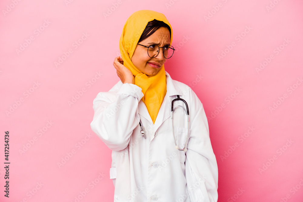 Young doctor muslim woman isolated on pink background suffering neck pain due to sedentary lifestyle.