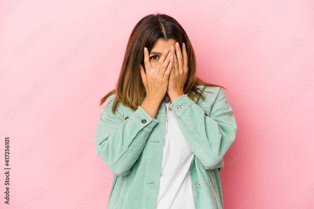Young indian woman isolated on pink background blink through fingers frightened and nervous. Young indian woman isolated on pink background blink through fingers frightened and nervous.