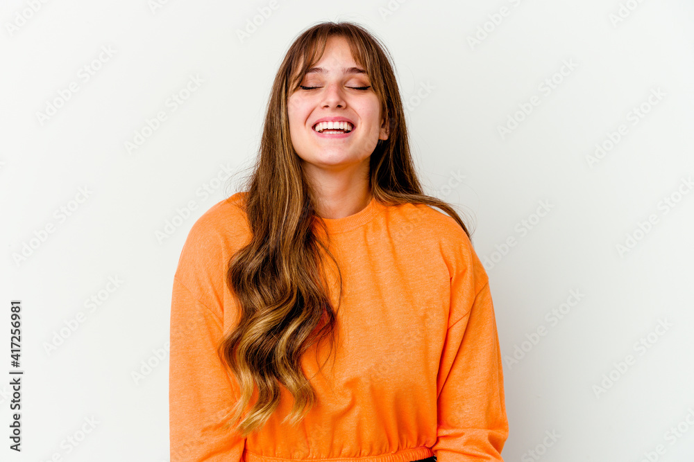 Obraz premium Young caucasian cute woman isolated on white background laughs and closes eyes, feels relaxed and happy.