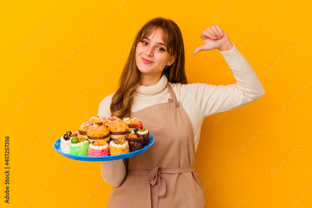 Young pastry chef woman isolated on yellow background feels proud and self confident, example to follow. Young pastry chef woman isolated on yellow background feels proud and self confident, example to follow.