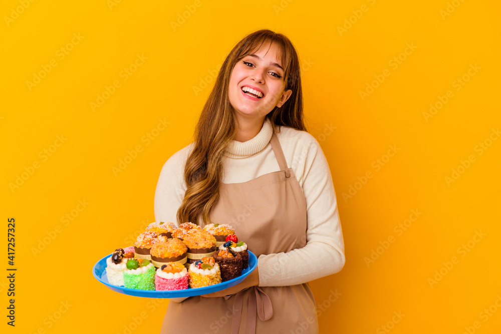 Young pastry chef woman isolated on yellow background laughing and having fun.