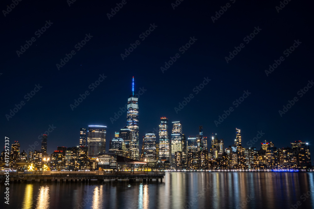Jersey City, NJ - USA - Feb. 27, 2021: Wide angle landscape view of New York City's skyline at night. Seen from the Jersey City waterfront.