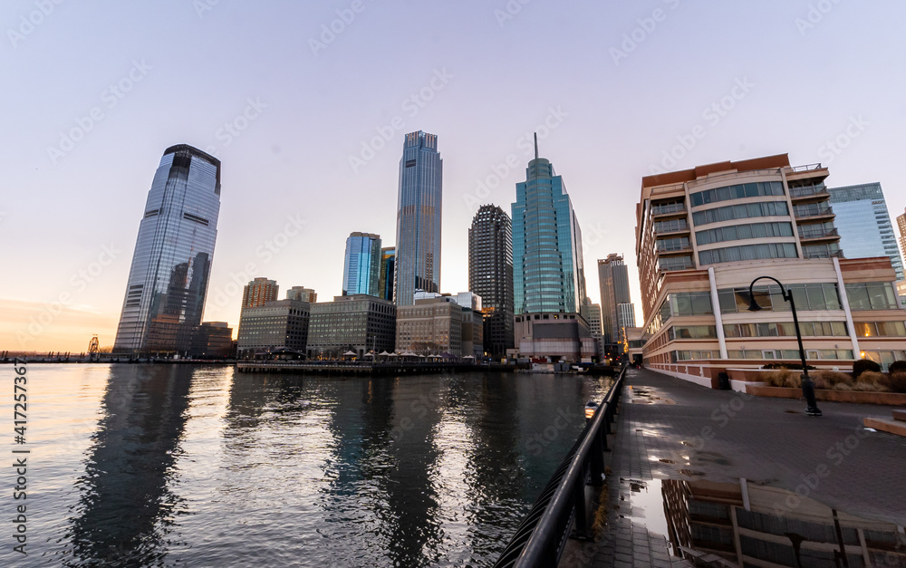 Obraz premium Jersey City, NJ - USA - Feb. 27, 2021: Landscape view of Jersey City's waterfront financial district, Exchange Place at sunset.
