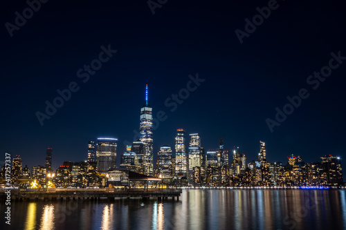 Jersey City, NJ - USA - Feb. 27, 2021: Wide angle landscape view of New York City's skyline at night. Seen from the Jersey City waterfront.