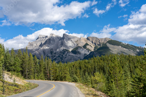 Mountain road in the forest in summer time. Lake Minnewanka scenic drive Loop. Banff National Park, Canadian Rockies, Alberta, Canada.