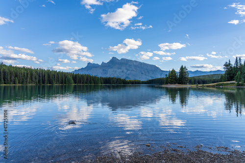 Two Jack Lake beautiful landscape in summer day. Mount Rundle with blue sky, white clouds reflected on water surface. Banff National Park, Canadian Rockies, Alberta, Canada.