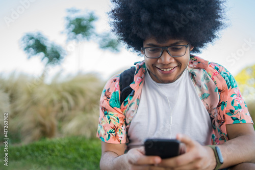 Young man using his mobile phone outdoors.