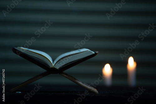 The Quran is placed on the plank in the mosque - open to prayers, the black background of Muslims around the world, placed on the wooden board, the Quran in the mosque - is open to prayer