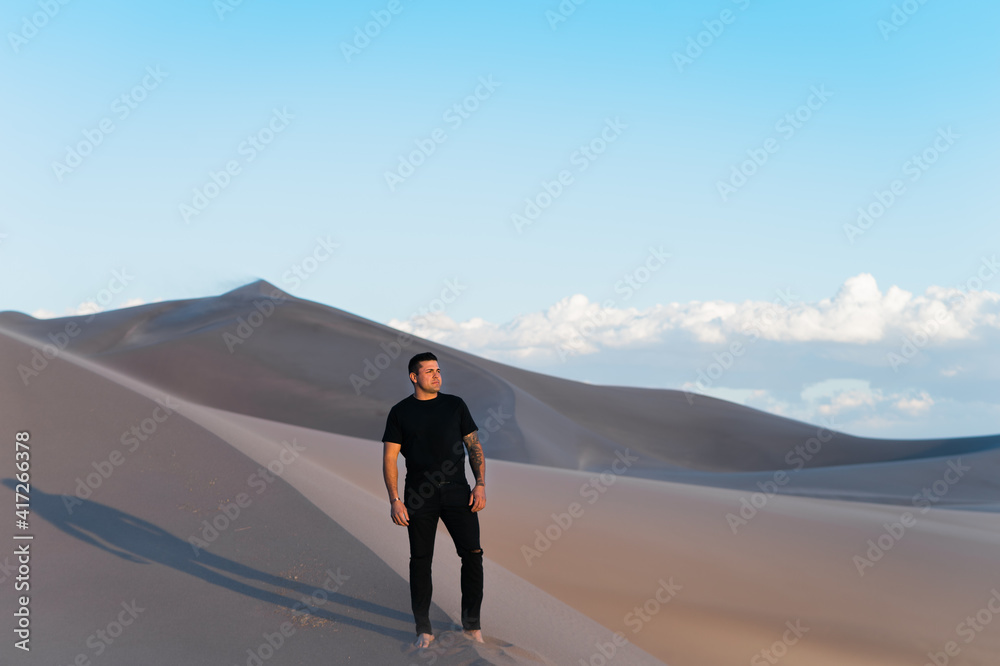 Man in black alone in white desert sand dunes Man in black alone in white desert sand dunes