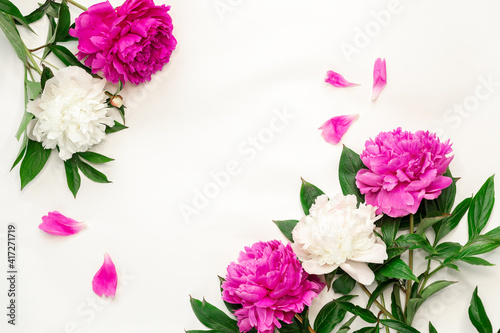 Pink and white peonies on white background. Top view, copy space - Image © lizaelesina