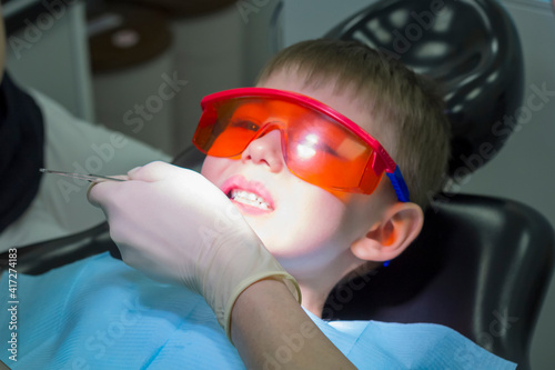 Kids dental medicine. Oral or dental examinations by dentist with medical equipment. Children's dentist examination baby teeth. Emotions of a child in a dental chair.