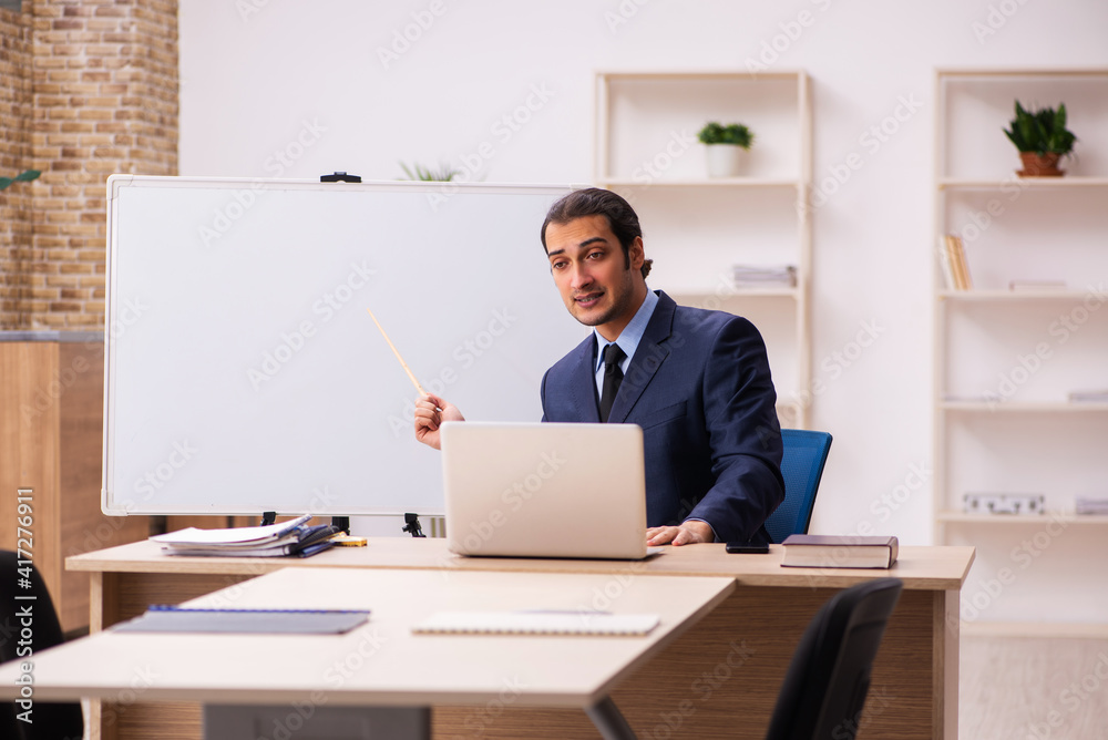 Young male employer in front of white board Young male employer in front of white board