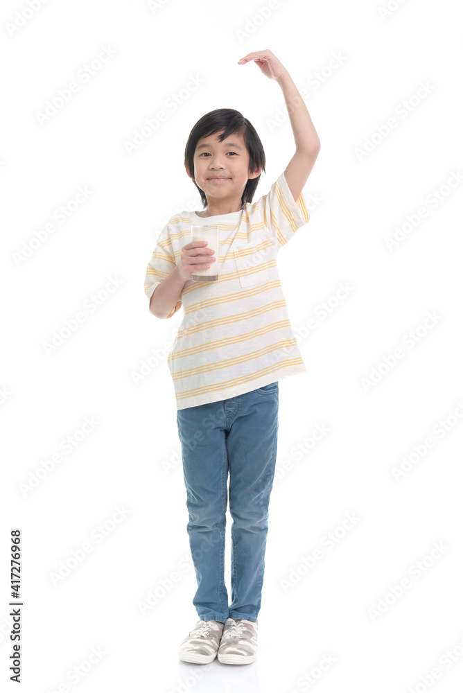 Asian child drinking milk from a glass and measuring himself on white background isolated Asian child drinking milk from a glass and measuring himself on white background isolated