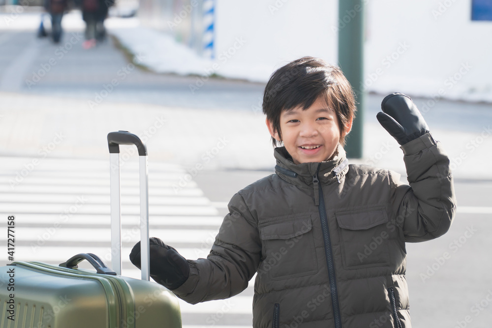 Obraz premium Cute happy Asian child with a suitcase