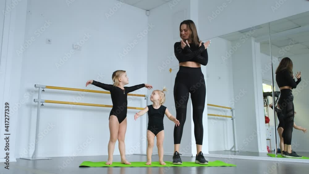 daughters with mom do a warm-up in the gym
daughters with mom do a warm-up in the gym