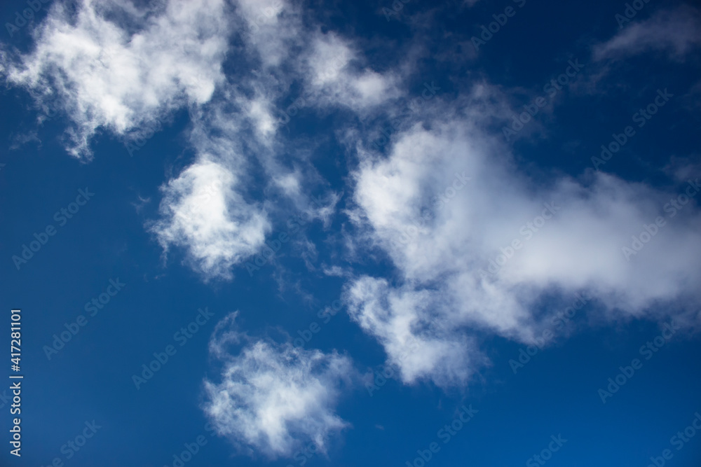 White clouds on a background of blue sky. Summer cloudy day.