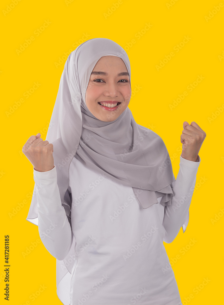 Portrait of young muslim woman in cool earth tone hijab and traditional clothes smile with power woman pose . Happy moment concept,isolated white background. Portrait of young muslim woman in cool earth tone hijab and traditional clothes smile with power woman pose . Happy moment concept,isolated white background.