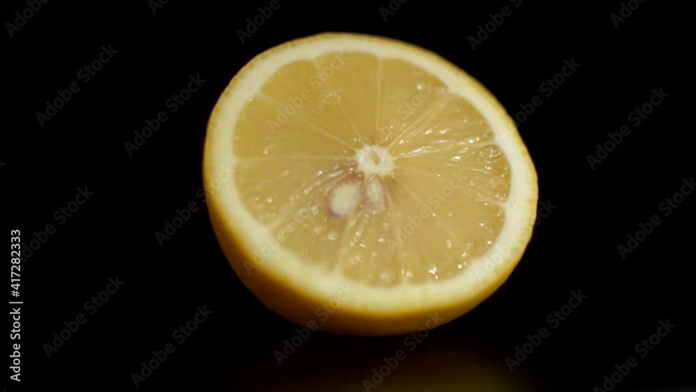 Halve lemon on black background with lights and shadows changing. Halve lemon on black background with lights and shadows changing.