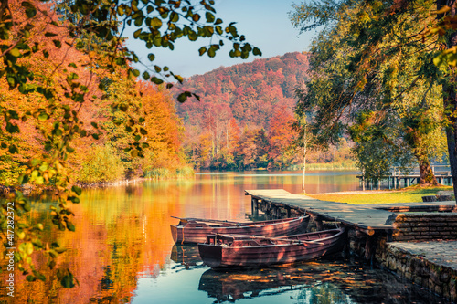 Beautiful autumn scenery. Stunning morning view of pure water lake with boats in Plitvice National Park. Colorful autumn scene of Croatia, Europe. Beauty of nature concept background.