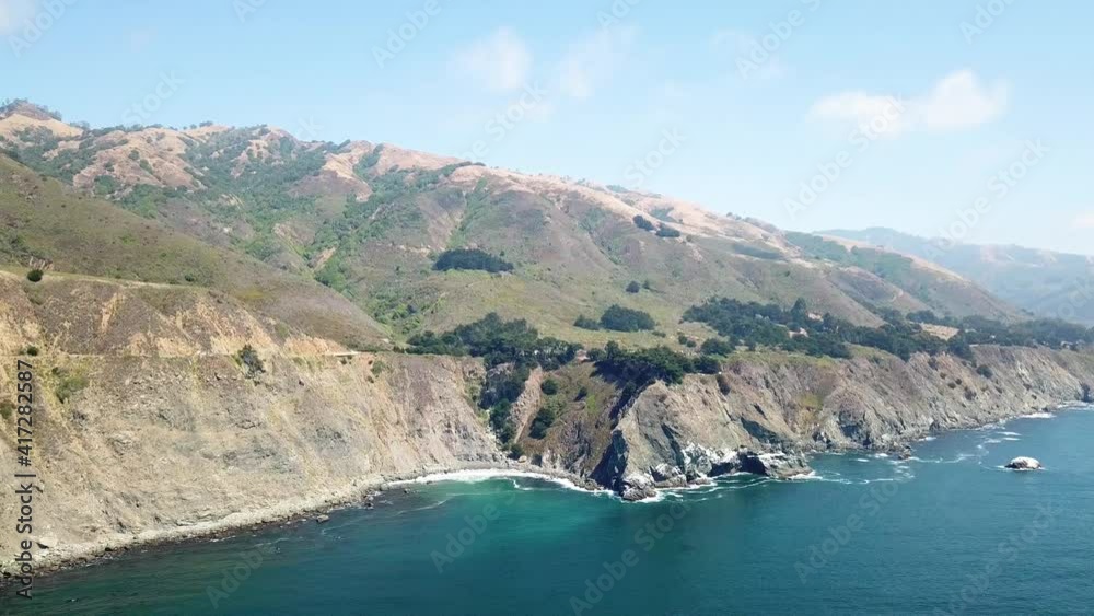 Stunning mountains above clear blue ocean on an almost clear day, California. Aerial dolly forwards Stunning mountains above clear blue ocean on an almost clear day, California. Aerial dolly forwards