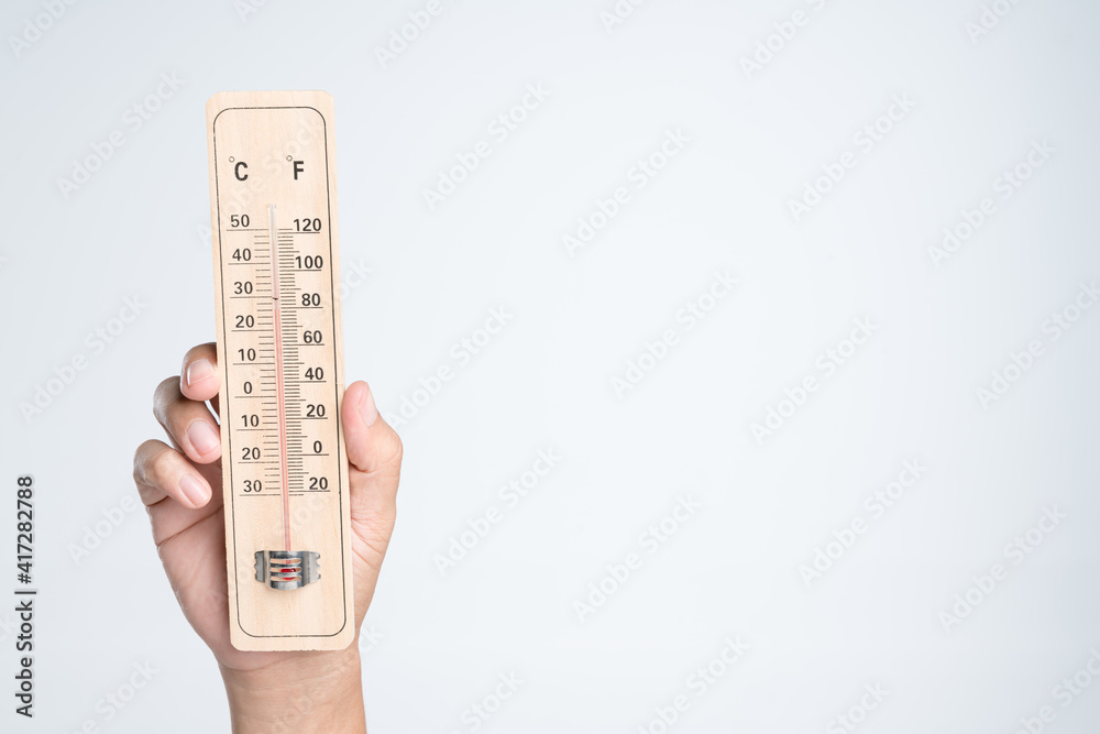 Hand holding classic thermometer for checking temperature Hand holding classic thermometer for checking temperature