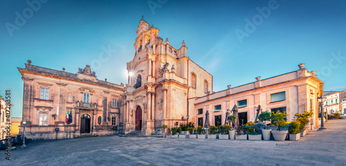 Empty Piazza Duomo square with Duomo San Giorgio - baroque Catholic church. Bright morning cityscape of Ragusa, Sicily, Italy, Europe. Traveling concept background. Wide angle picture.