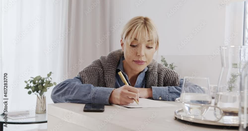 Home budget and finances. Counting the household budget, a satisfied woman counts and records expenses. Home budget and finances. Counting the household budget, a satisfied woman counts and records expenses.