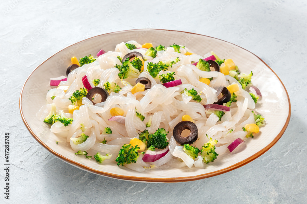 Konjac pasta, a plate of low-calorie fettuccine with broccoli, onions, and other vegetables, a healthy vegan dinner Konjac pasta, a plate of low-calorie fettuccine with broccoli, onions, and other vegetables, a healthy vegan dinner