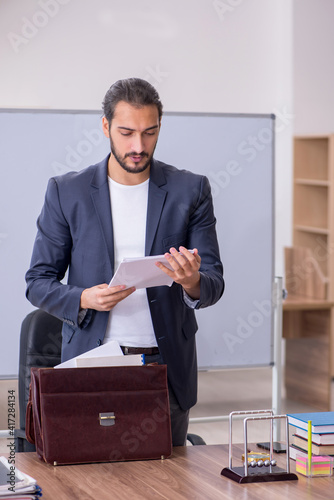 Young male teacher physicist in the classroom