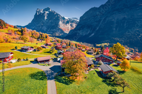 Aerial landscape photography. Colorful autumn view of Grindelwald village valley from cableway. Wetterhorn and Wellhorn mountains, Switzerland, Europe. Traveling concept background.. photo