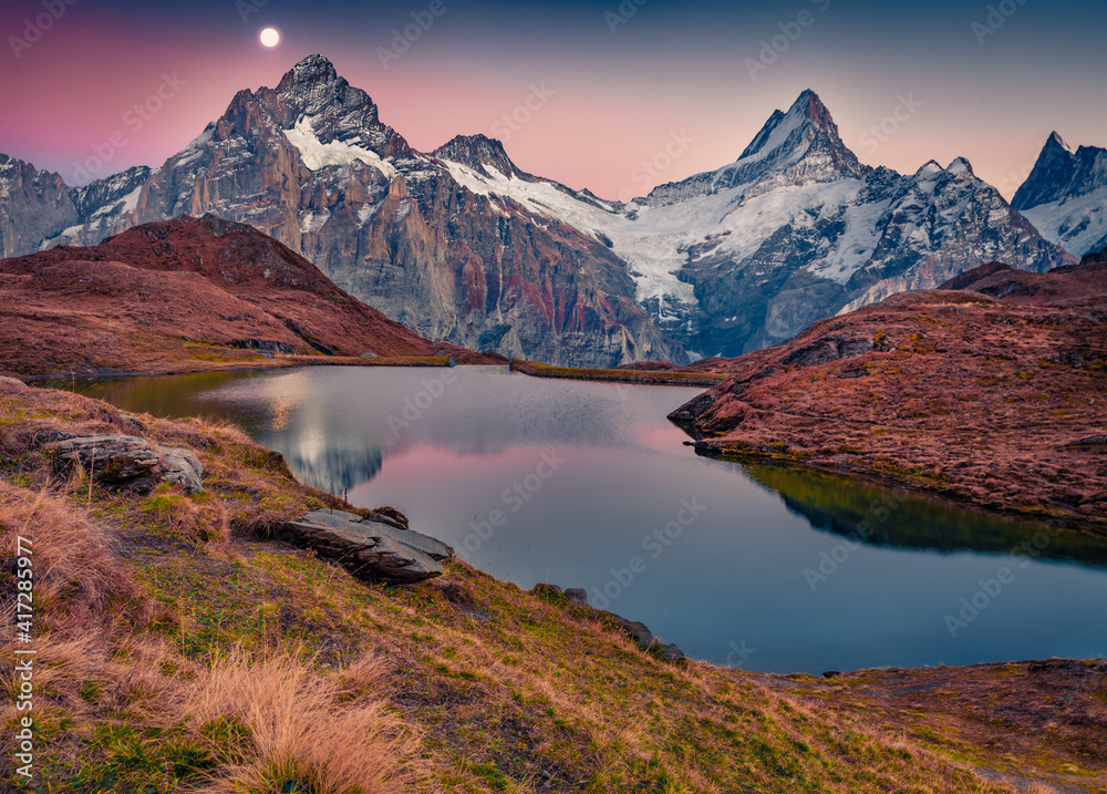 Rising moon on Bachalp lake (Bachalpsee), Switzerland. Captivating autumn suset in Swiss alps, Grindelwald, Bernese Oberland, Europe. Beauty of nature concept background.
